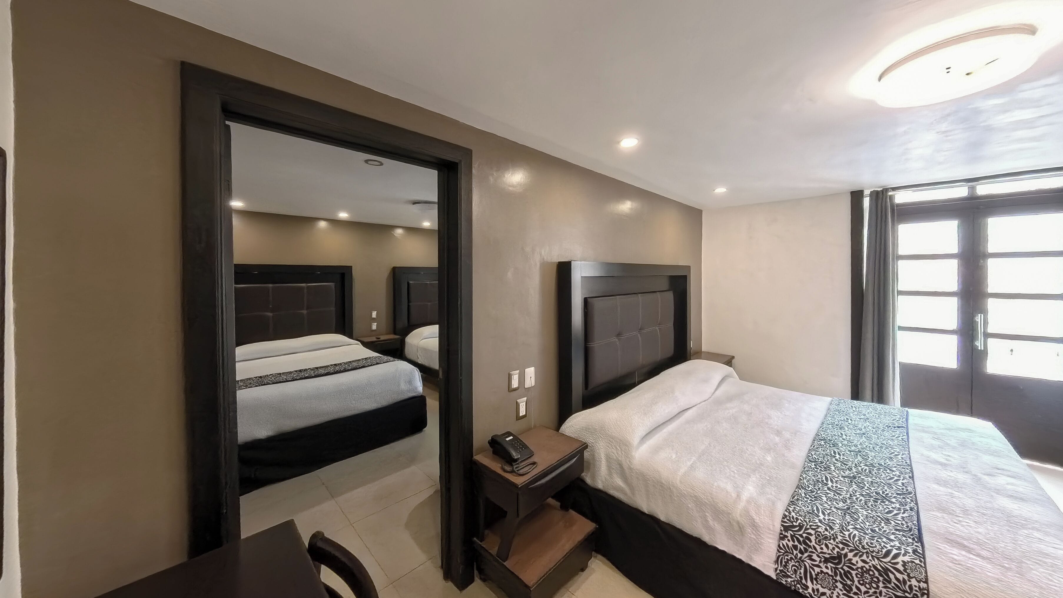 Una habitación de hotel con dos camas, un escritorio y una silla.