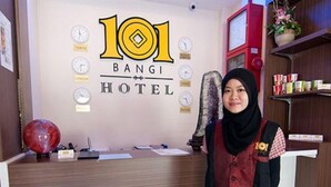 A hotel reception desk with a clock, a red spherical object, and a sign reading "101 BANGI HOTEL". - 101 Hotel Bangi (Bandar Baru Bangi)
