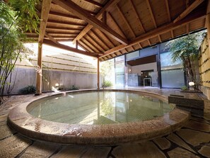 A hot spring area with a wooden ceiling, stone flooring, and a glass wall. - Nikko Station Hotel Classic (Nikko)
