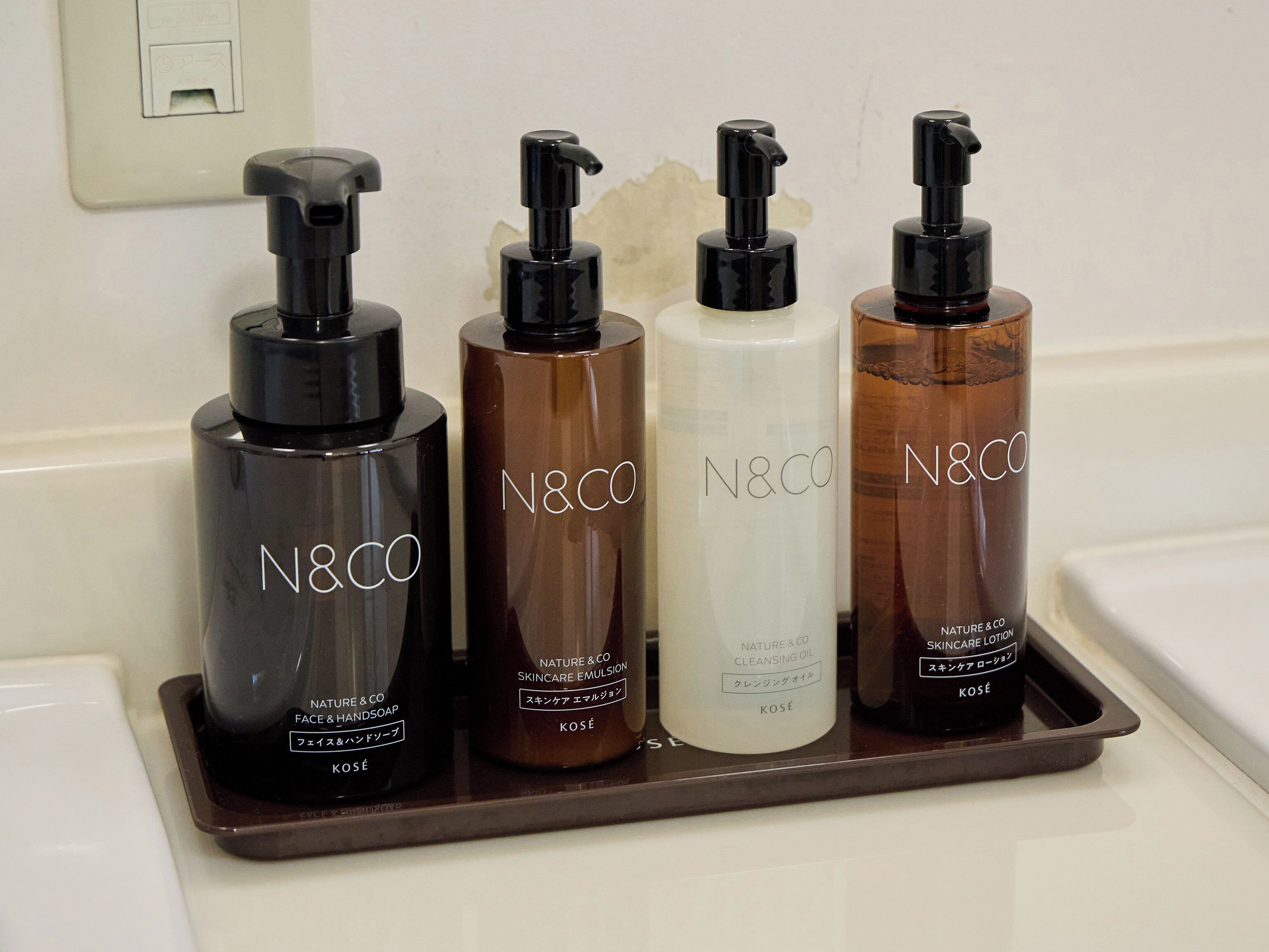 Four N&CO skincare products on a tray.