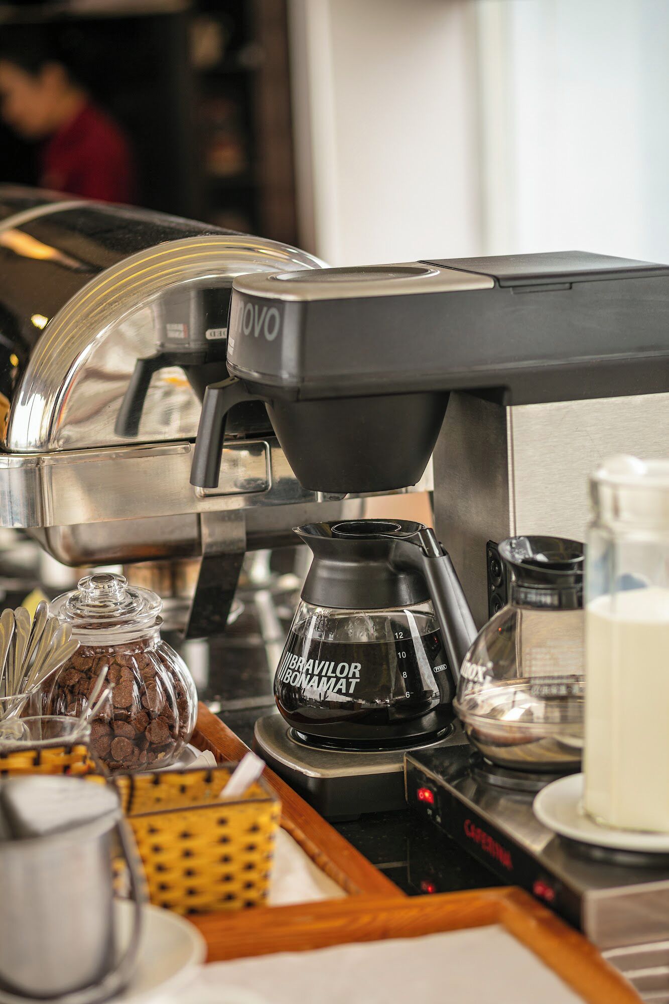 A coffee machine with a transparent water tank and a coffee pot.