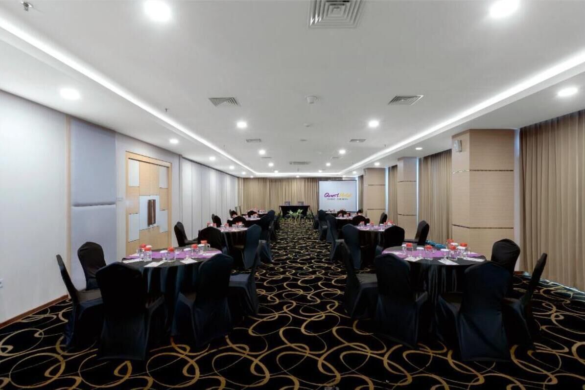 A conference room with a long table, chairs, and a projector screen.