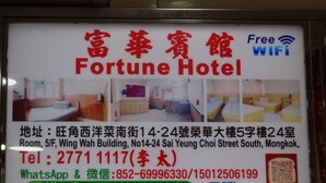 Placa do Fortune Hotel com detalhes dos quartos, informações de contato e comodidades como WiFi gratuito.