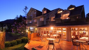 Un hotel con un patio cubierto al aire libre, varias mesas y sillas para comer.