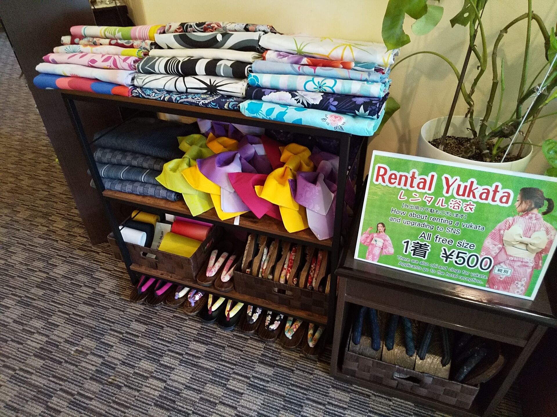 A display of colorful yukata fabrics and a sign advertising rental services.
