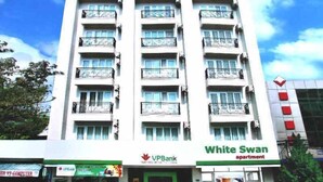 A multi-story building with a white facade, featuring a 'White Swan apartment' sign. - White Swan Apartment (Nha Trang)