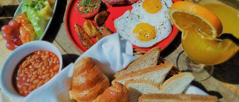 Un piatto colazione con uova, salsiccia, pomodori e pane tostato.