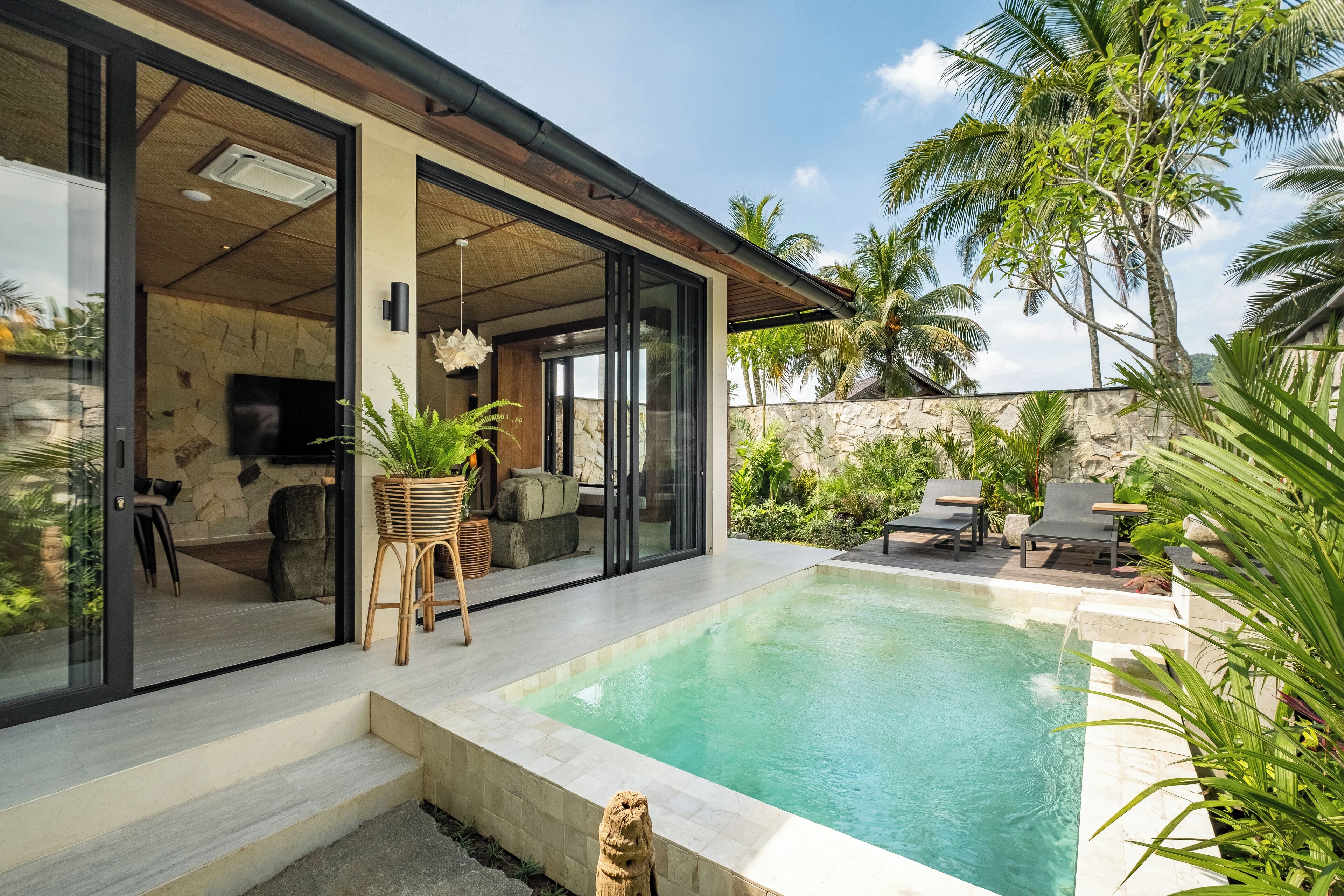 A modern house with a swimming pool, large glass doors, and outdoor furniture.