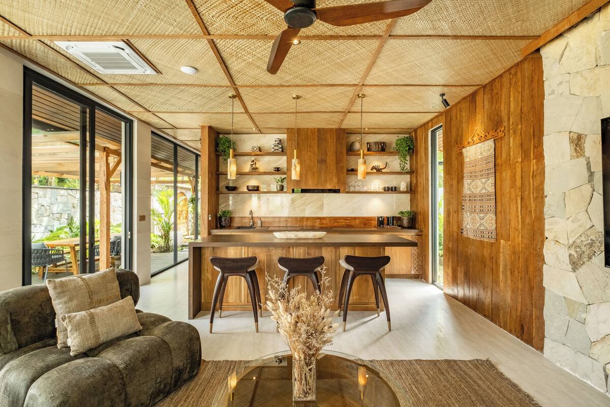 A modern kitchen with wooden accents, a central island, and bar stools.