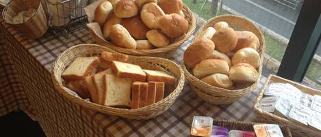 A table with baskets of bread, milk, and packaged goods.