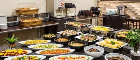 Een buffet met diverse gerechten en een koffieapparaat.