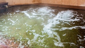 Un bain à remous où l’eau bouillonne et où de la mousse se forme à la surface.