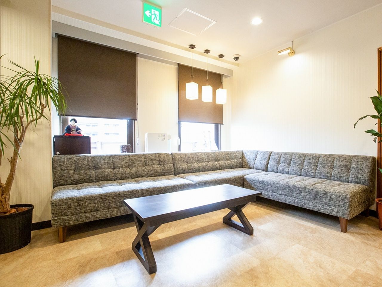 A modern waiting area with a sofa, a coffee table, and a potted plant.