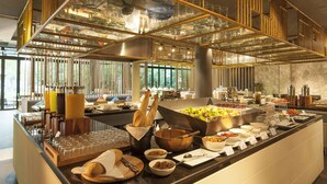 A buffet setup with various food items, utensils, and glassware. - Botanica Khao Yai (Pak Chong)