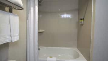 Un baño con bañera, cortina de ducha y toallero.