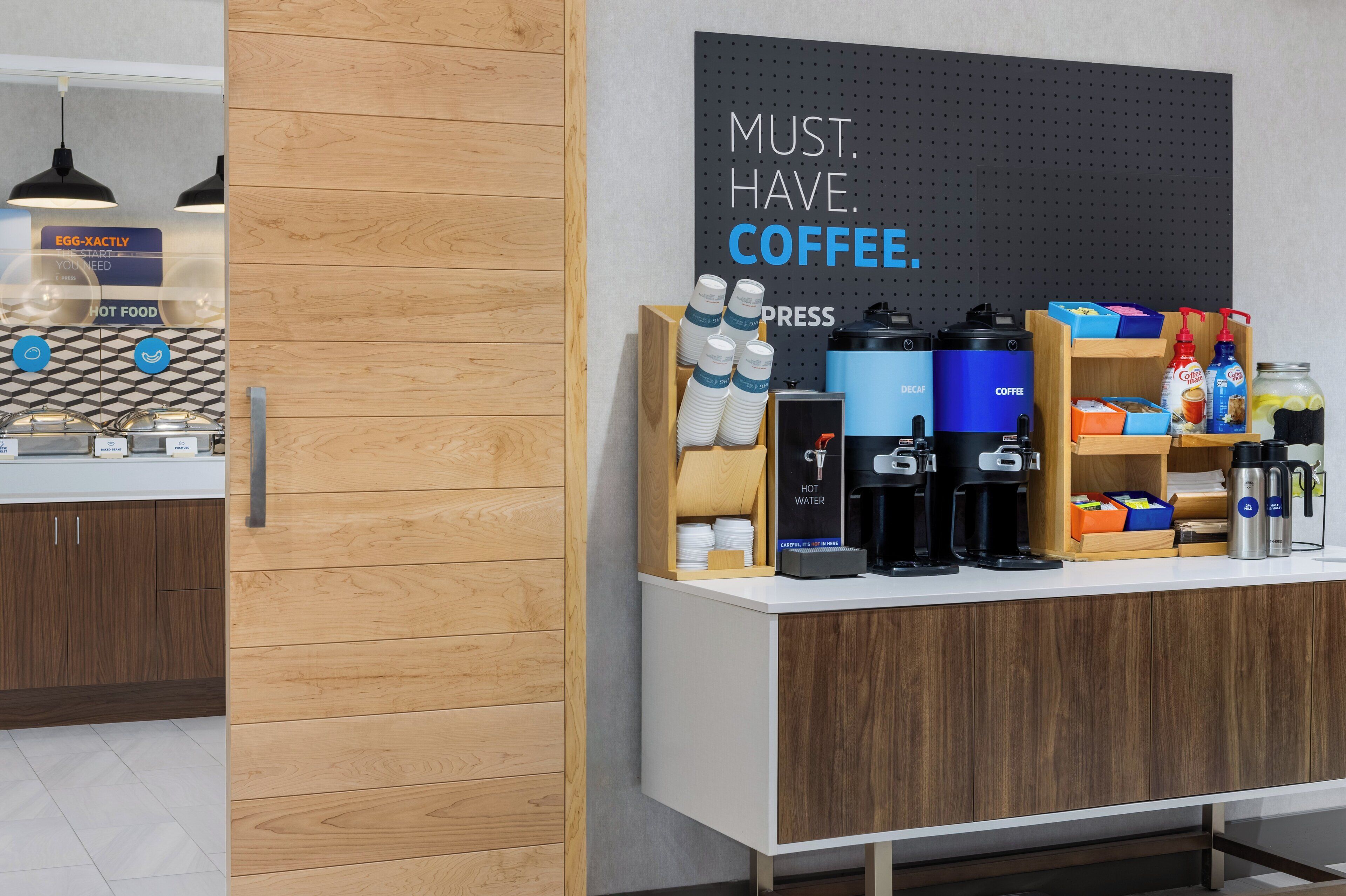 Una estación de café con un letrero que dice 'MUST. HAVE. COFFEE'.