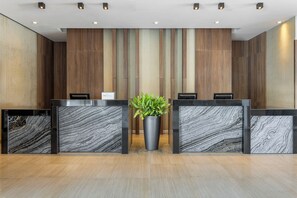 Ein Empfangsschalter mit einem Blumentopf, Holzvertäfelung und Marmor-Panels.