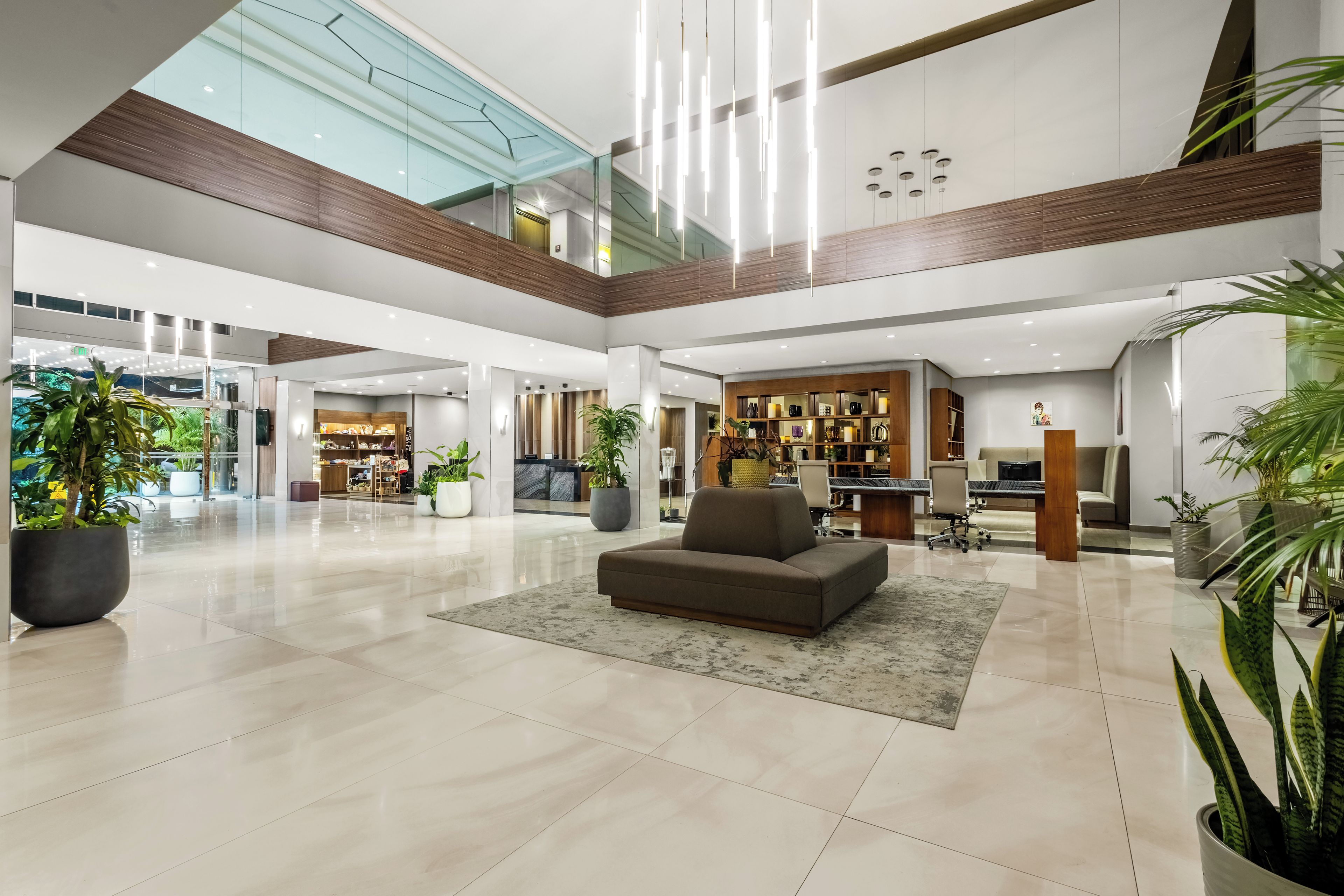 A spacious lobby with a high ceiling, a seating area, and a reception desk.