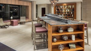 Un comedor moderno con una mesa y sillas de madera, una estantería empotrada y un colgador de luz decorativo.