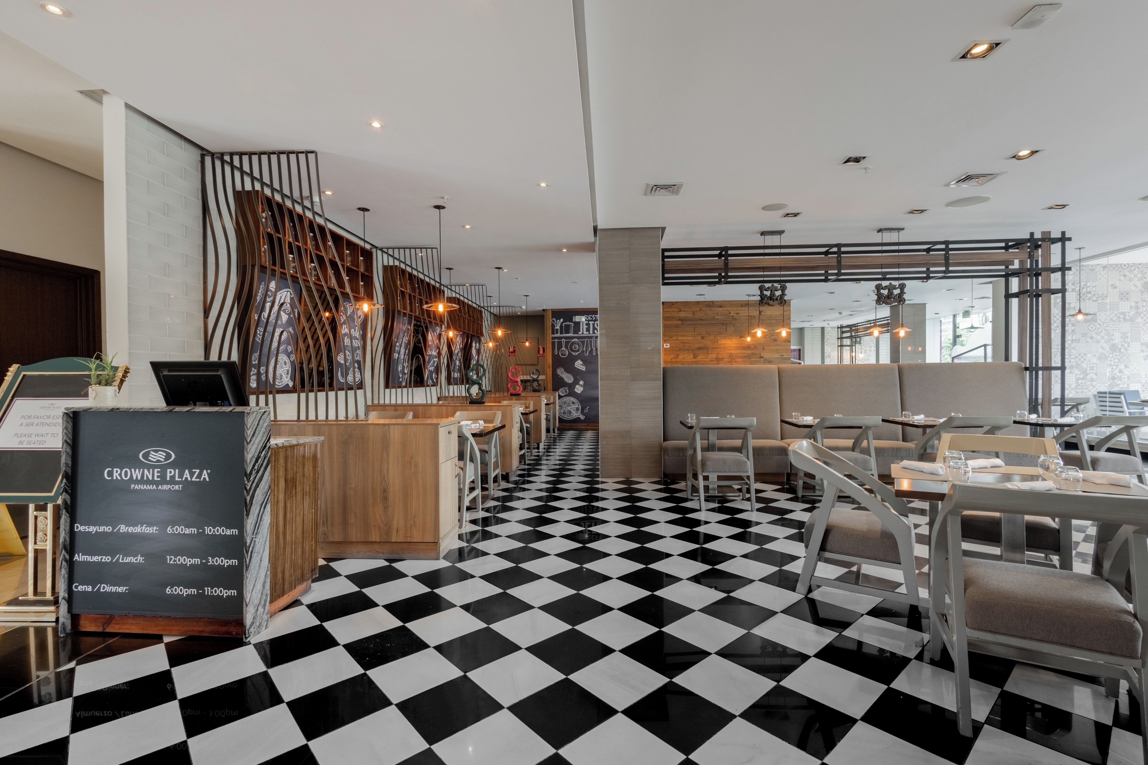 A restaurant with a checkered floor, wooden bar area, and seating.