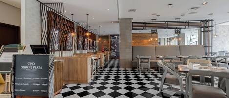 A restaurant with a checkered floor, wooden bar area, and seating.