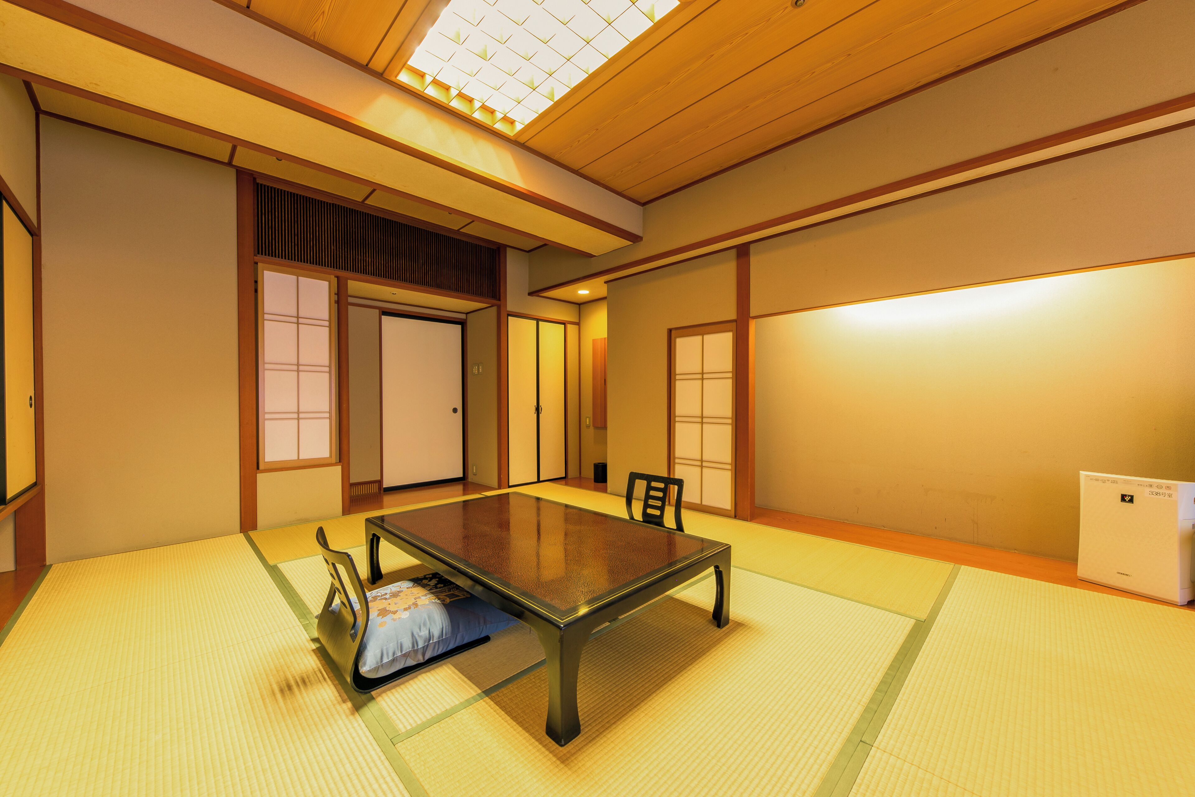A traditional Japanese room with tatami flooring, a low table, and sliding doors.
