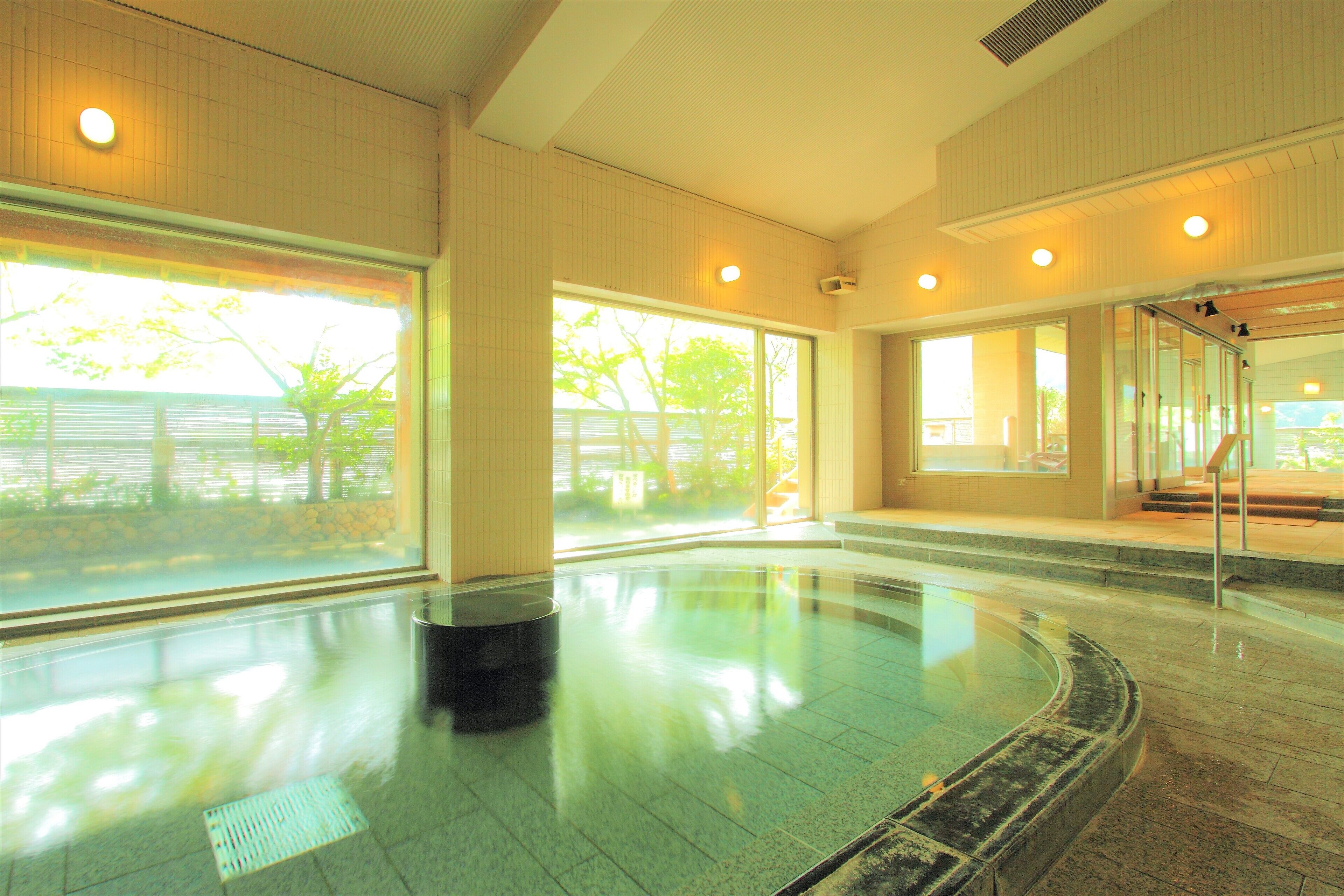 A spacious indoor swimming pool with clear views of the outdoors through large windows.