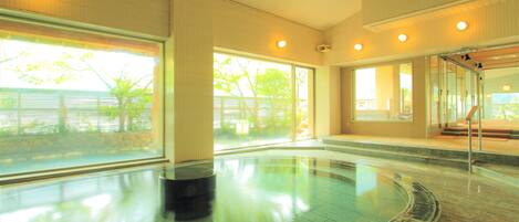 A spacious indoor swimming pool with clear views of the outdoors through large windows.