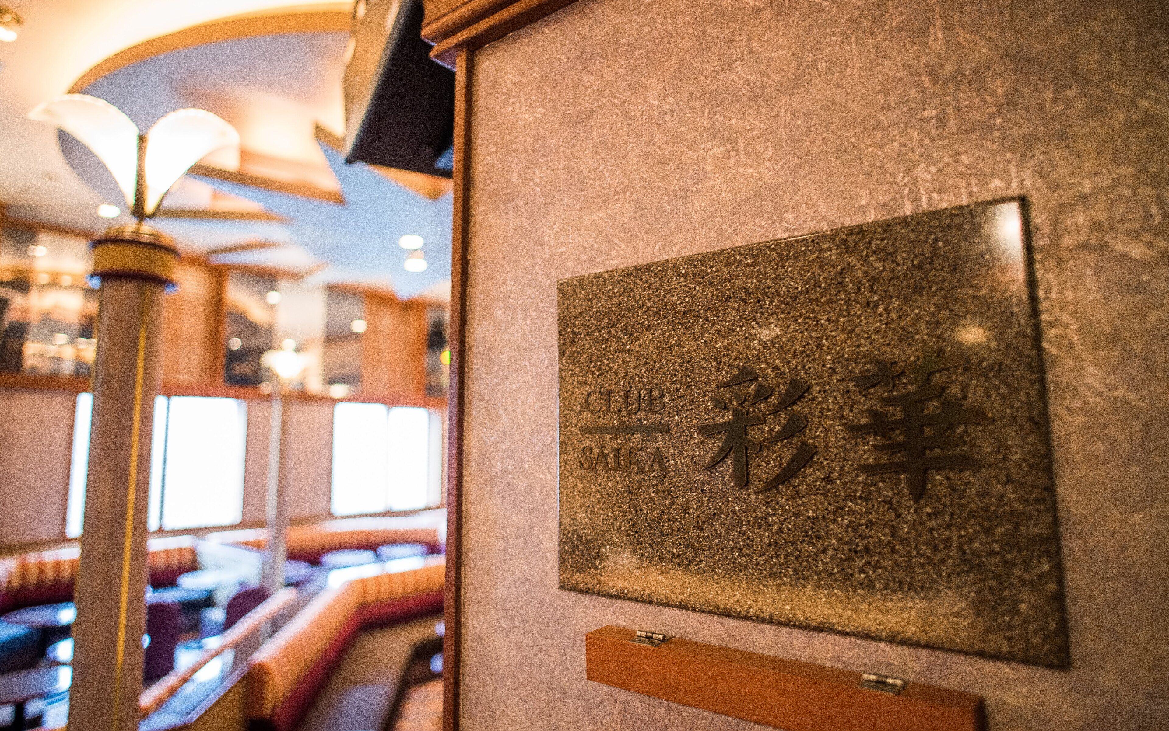 Un letrero con caracteres japoneses en una pared texturizada en un restaurante.