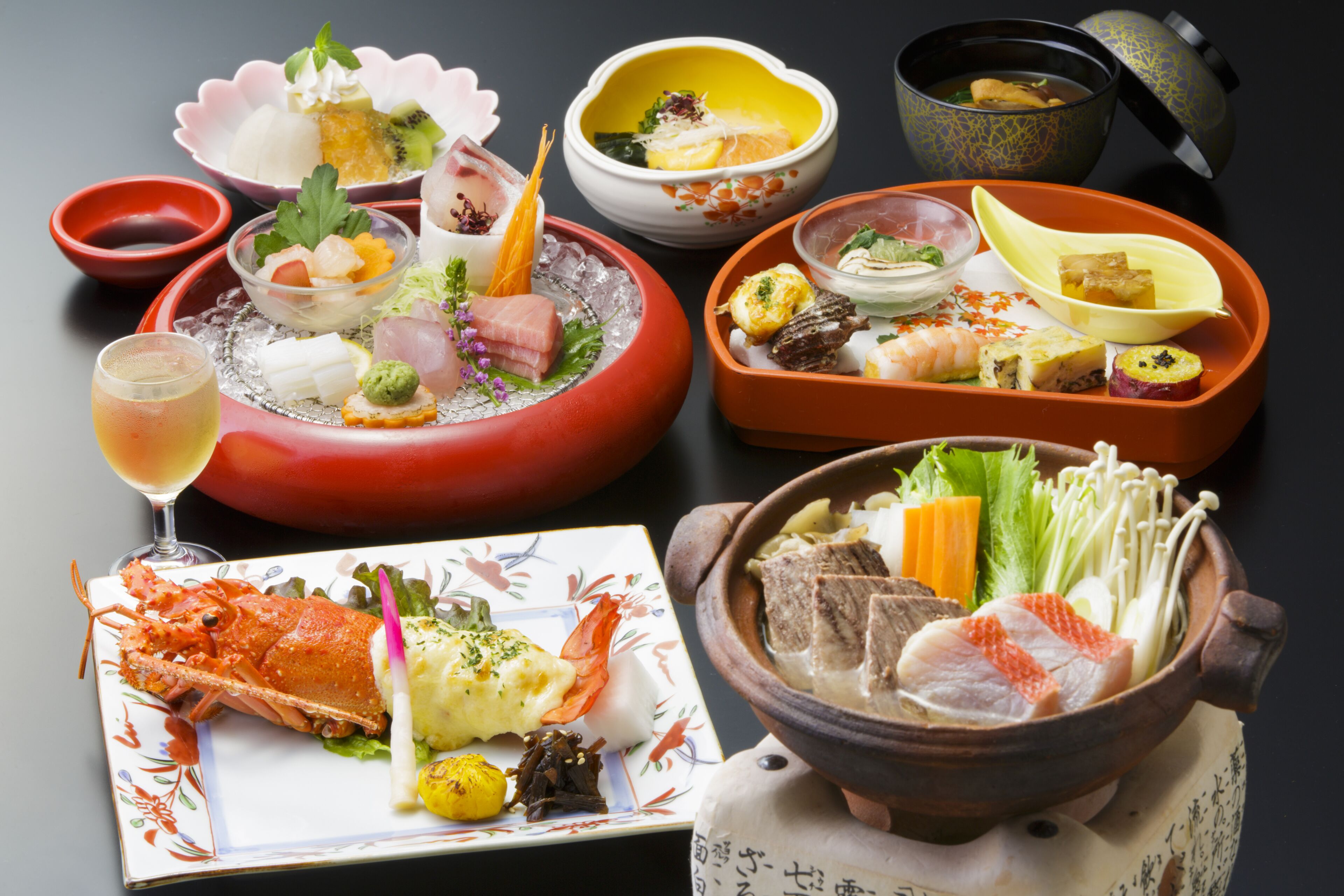 Diverse Japanse gerechten, waaronder vis, groenten en tofu, geserveerd op traditioneel keramiek en porselein.