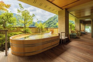 Una bañera de madera con vista a un paisaje montañoso.