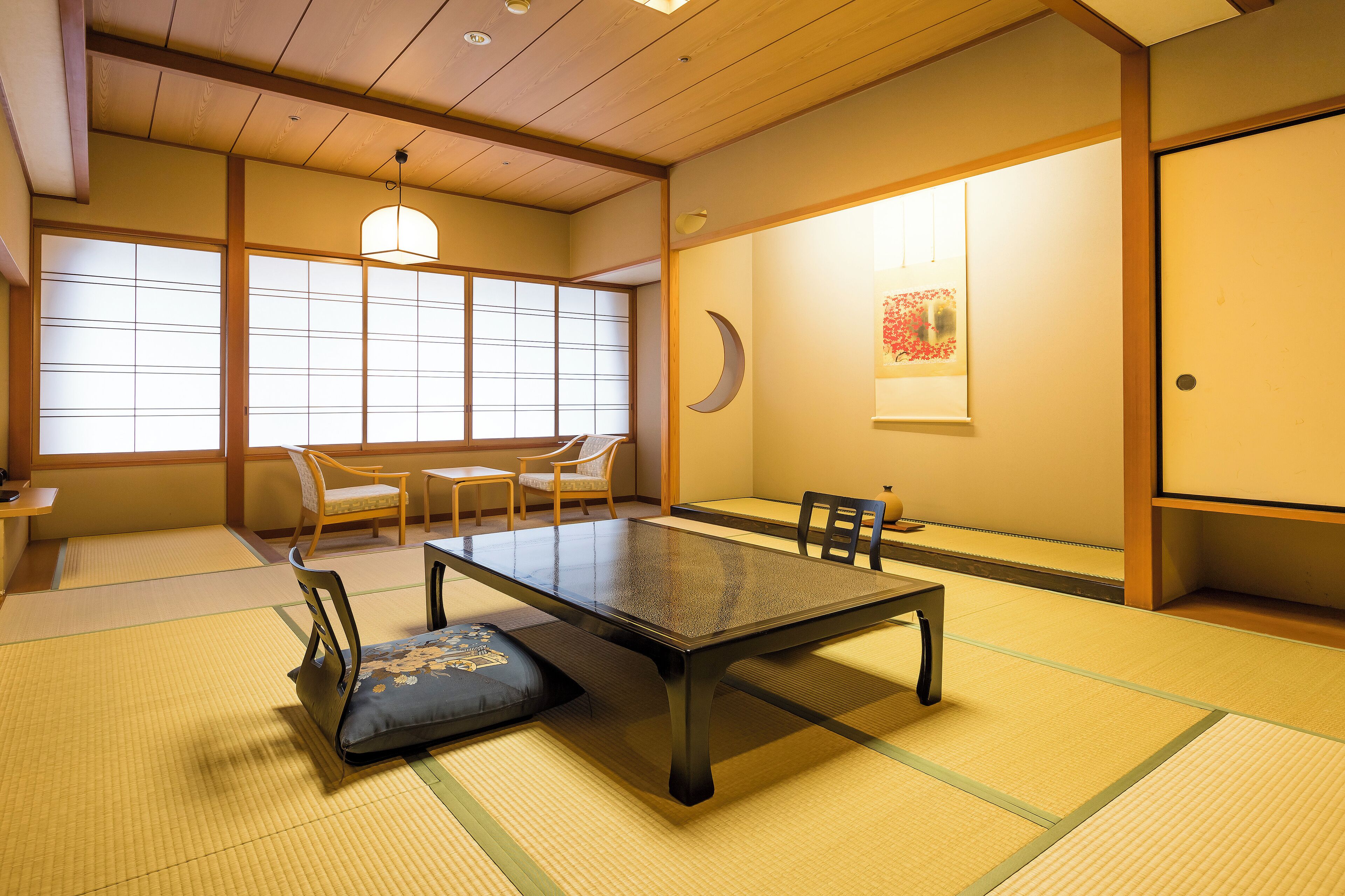 A traditional Japanese room with tatami flooring, a low table, and sliding doors.