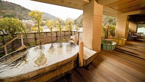 A wooden hot tub with a view of a mountainous landscape. - Hotel Kajikaso (Hakone)
