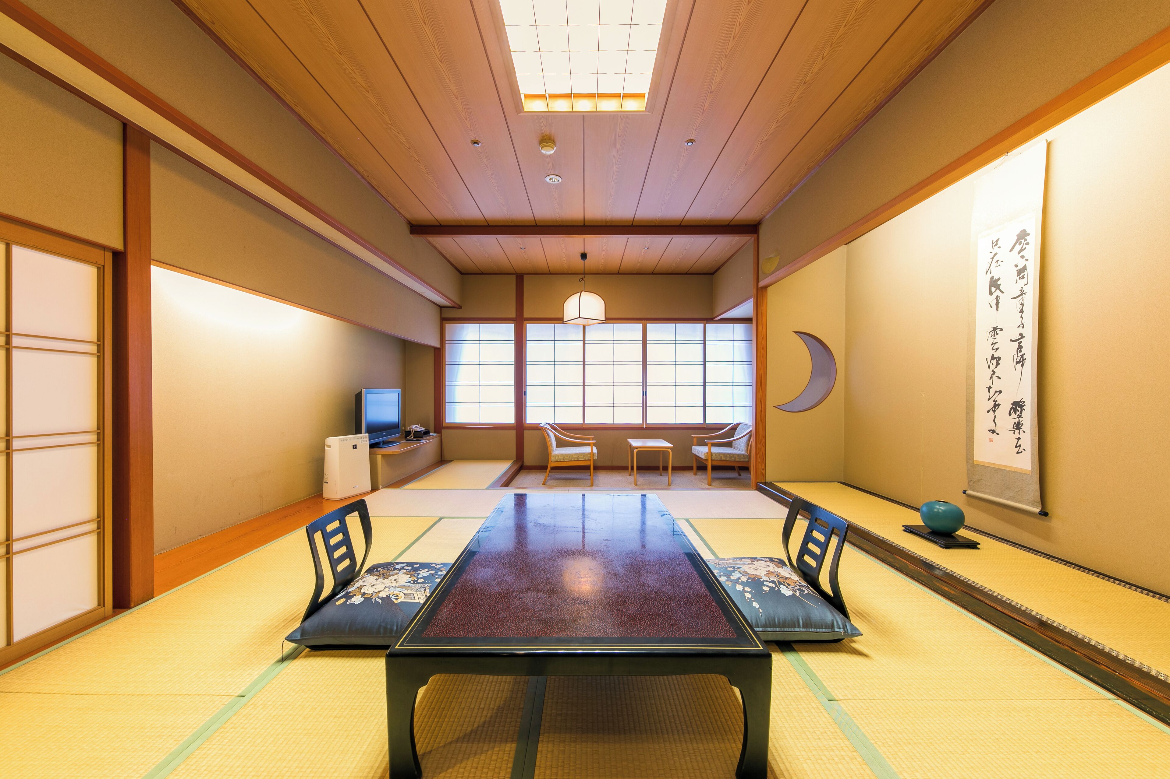A traditional Japanese room with tatami flooring, a low table, and shoji screens.