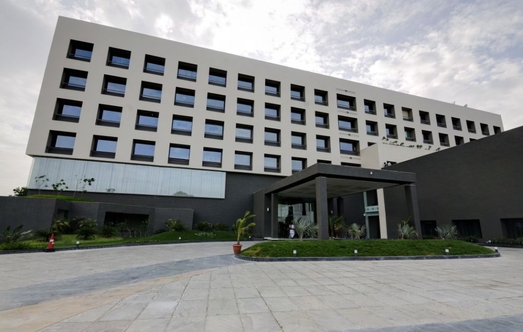 A modern building with a flat facade, multiple windows, and a covered entrance area.