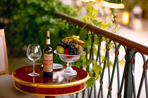 Een tafel met een fles wijn, een glas en een schaal fruit.