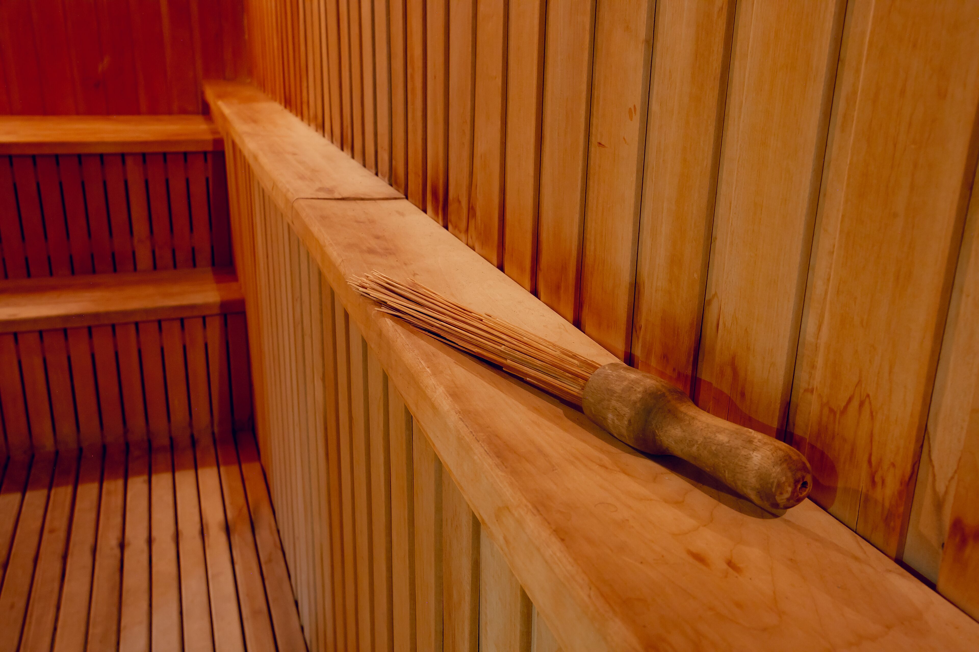 Un banc de sauna en bois doté d’une longue poignée.