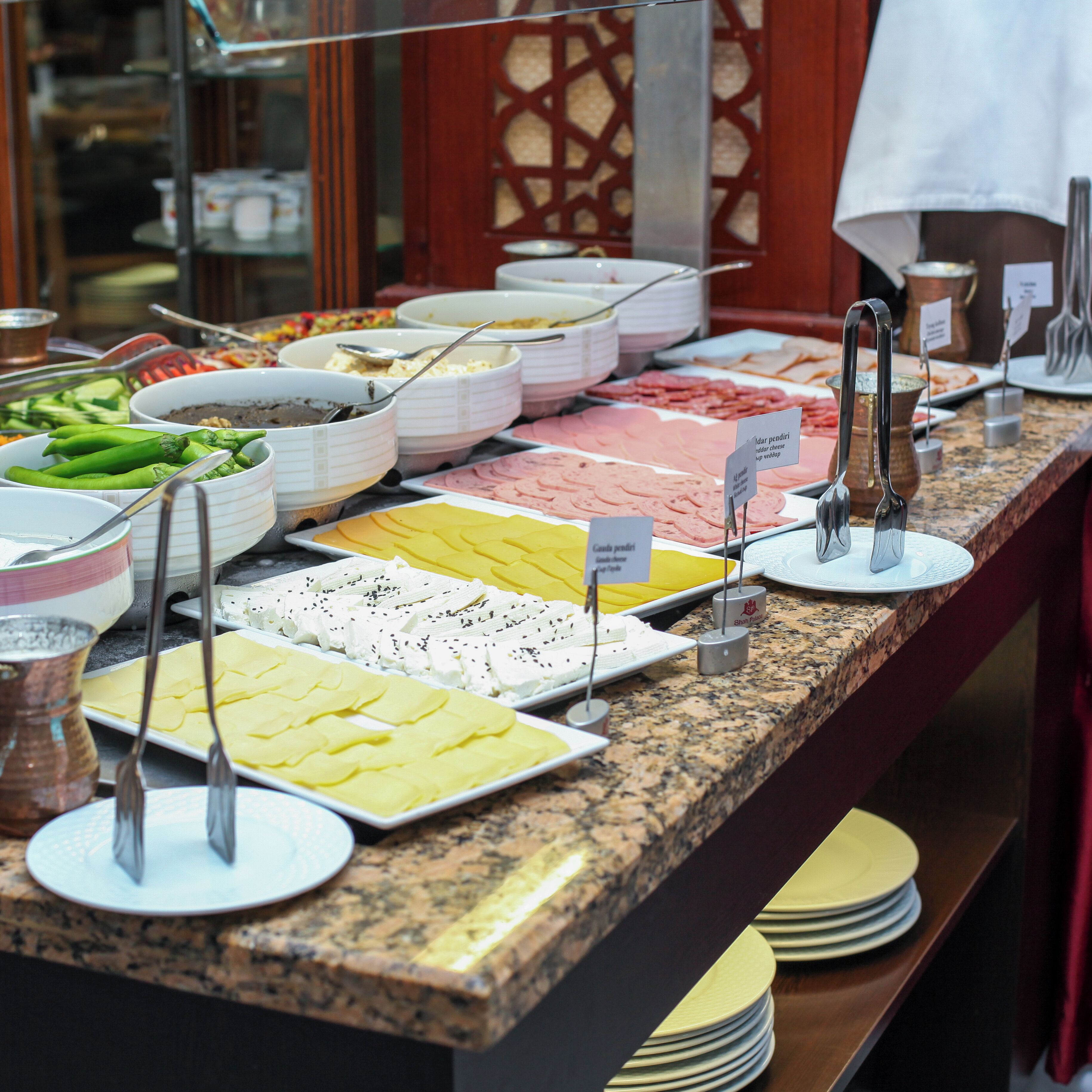 A buffet with various food items and utensils.