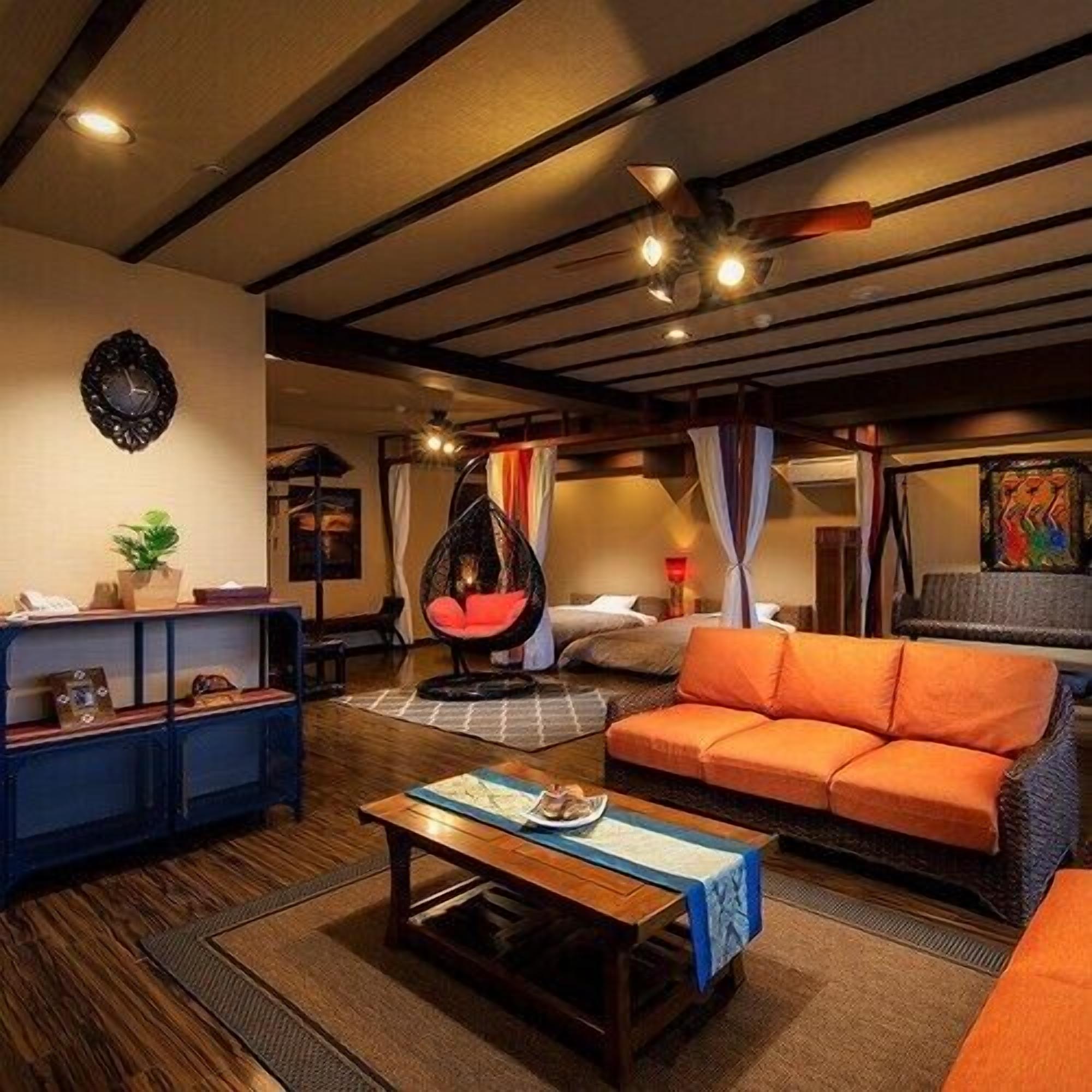 Een knusse woonkamer met een bank, een hangstoel, een bijzettafeltje en een boekenkast.
