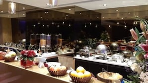 Zona de bufé con diversas opciones de comida y flores decorativas.