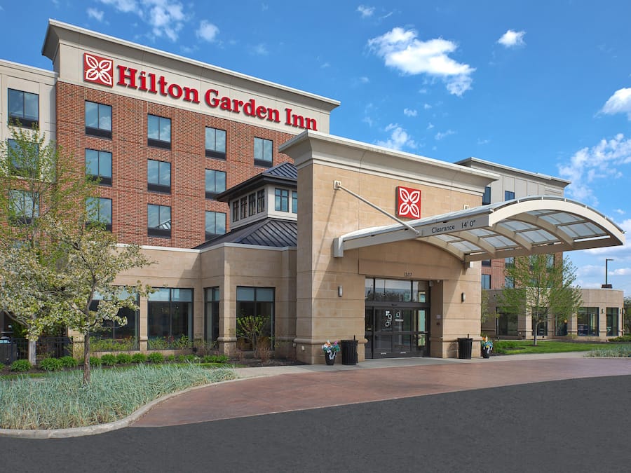 A Hilton Garden Inn with a brick facade, large windows, and a covered entrance.