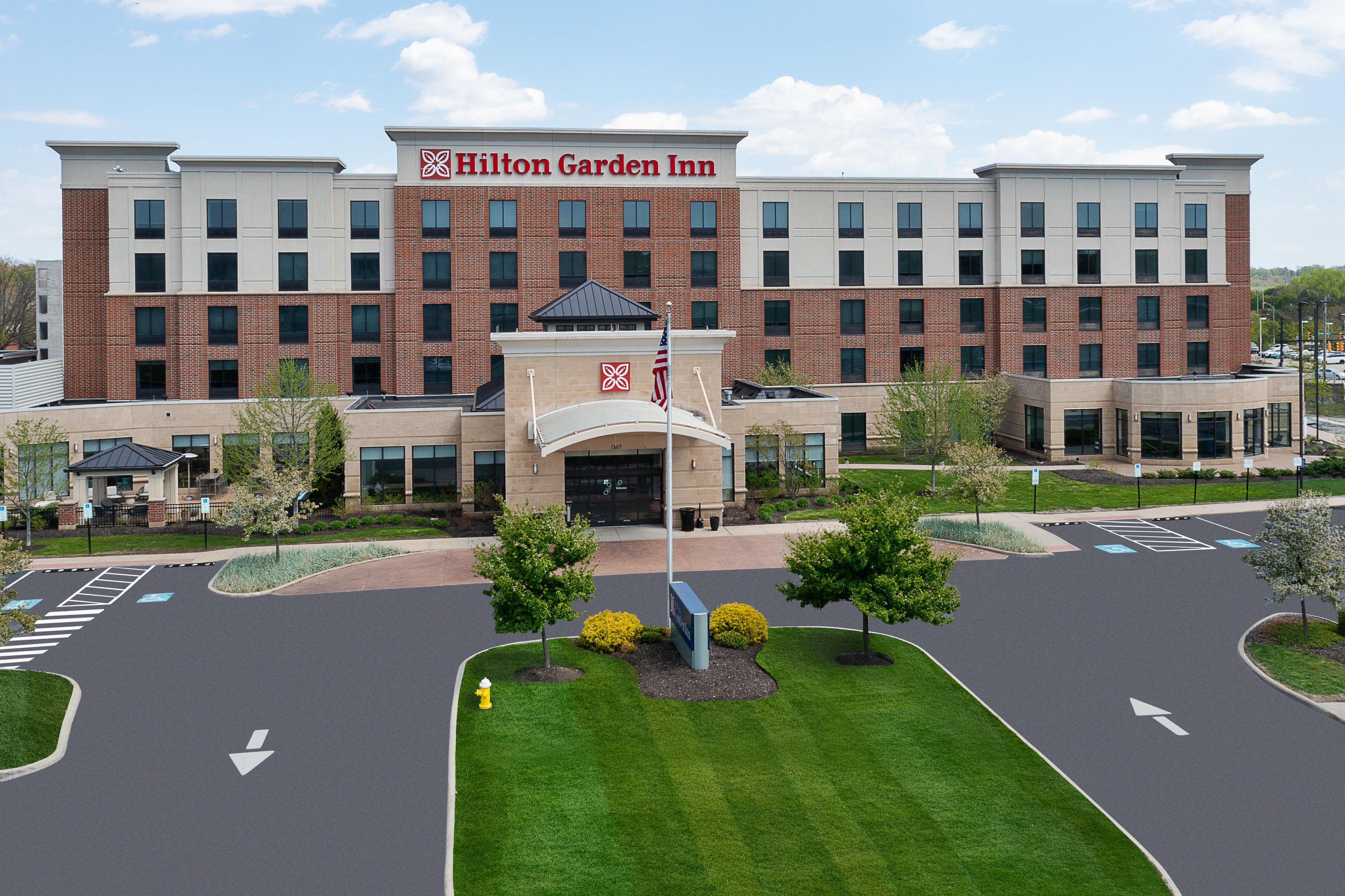 A Hilton Garden Inn with a brick facade, large windows, and a central entrance.