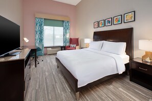 A hotel room with a bed, desk, chair, TV, and artwork on the wall. - Hilton Garden Inn Akron (Akron)