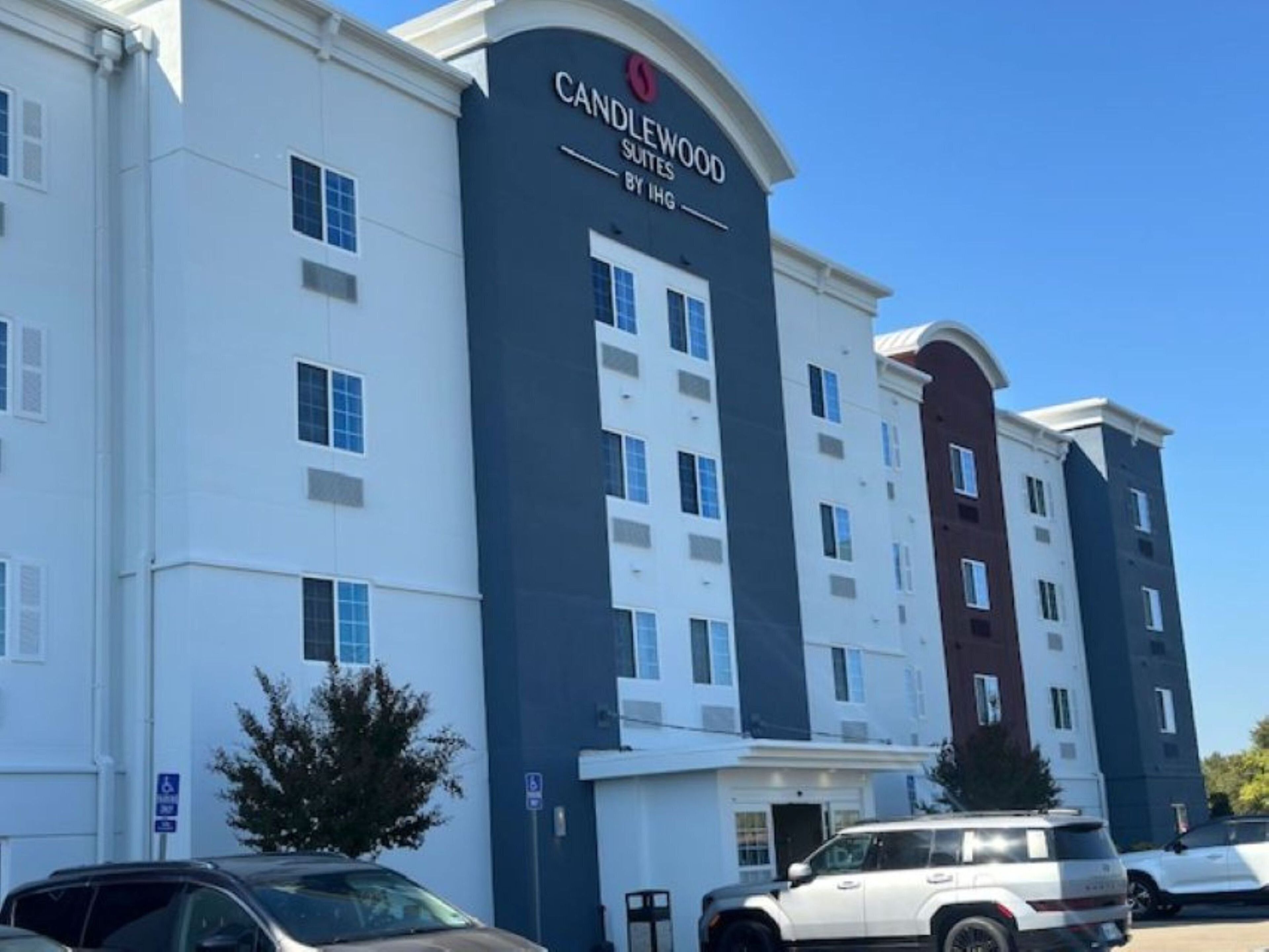 Un hotel de varios pisos con un llamativo letrero que dice "Candlewood Suites".