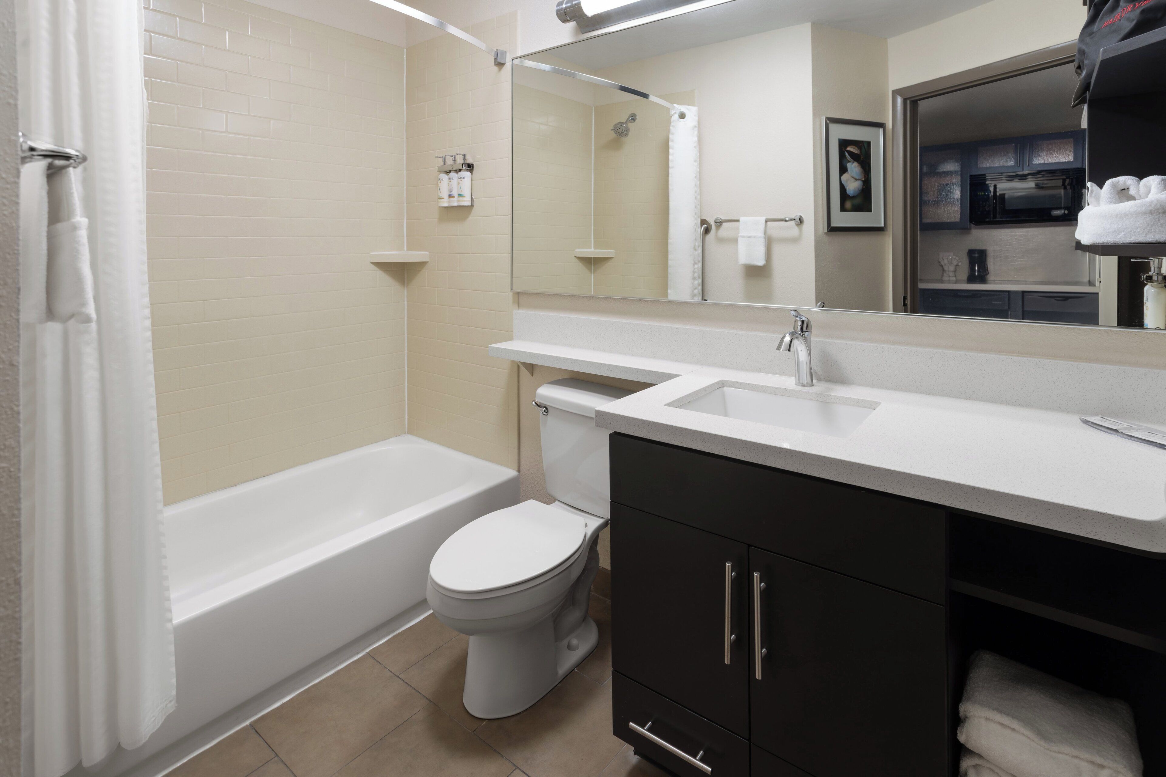 A modern bathroom with a bathtub, toilet, and vanity.