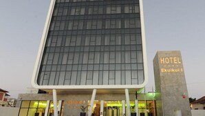 A modern hotel building with a large glass facade and a prominent sign indicating it is the Ekuiku Hotel. - Hotel Ekuikui I (Huambo)