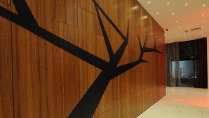 A modern interior with a wooden wall and a black tree-like design. - Hotel Ekuikui I (Huambo)
