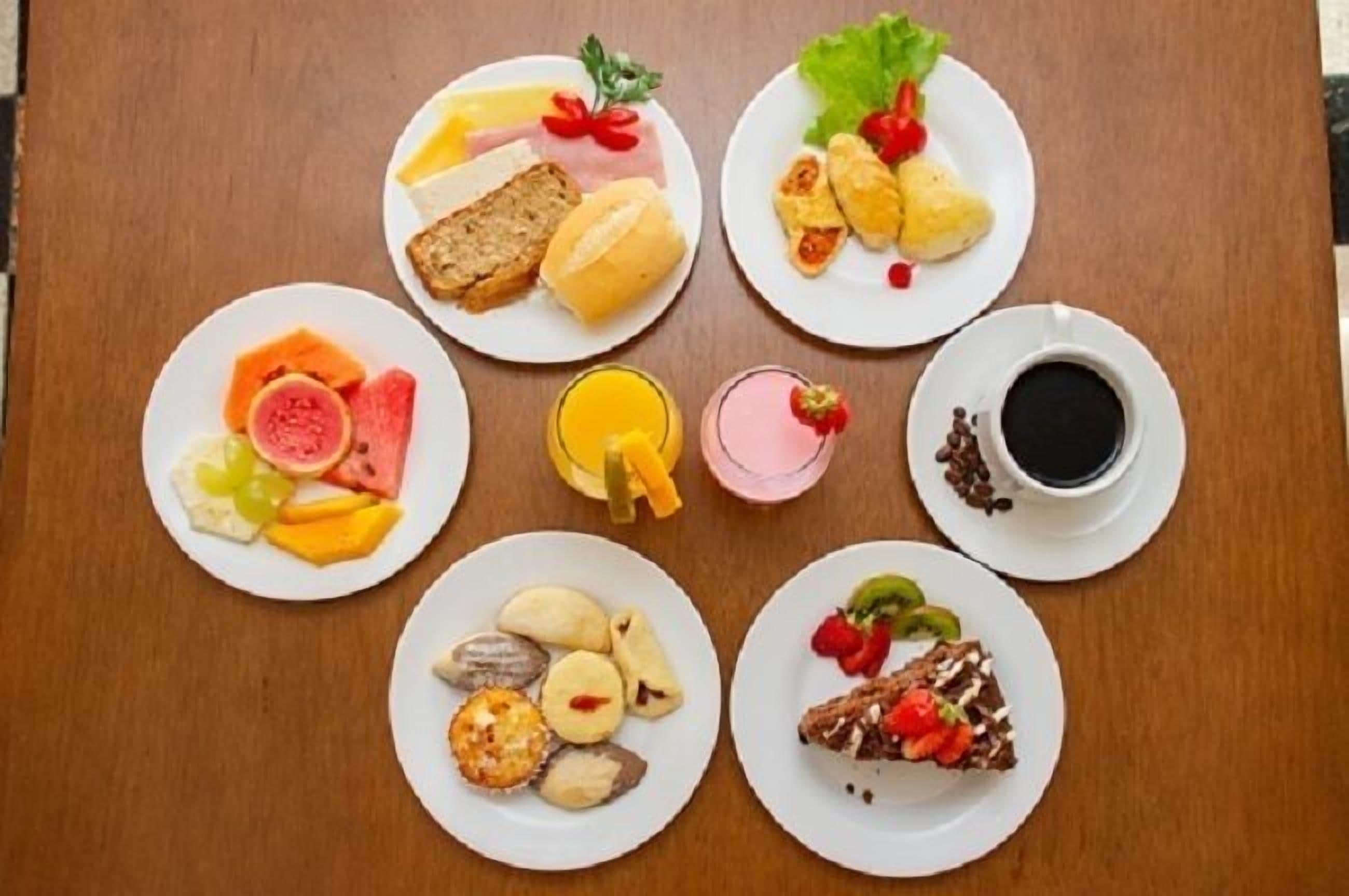 Uma mesa com diversos itens de café da manhã, como torradas, ovos, frutas e café.