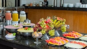 Un buffet proposant une variété de plats, notamment des fruits, des salades et des sauces.