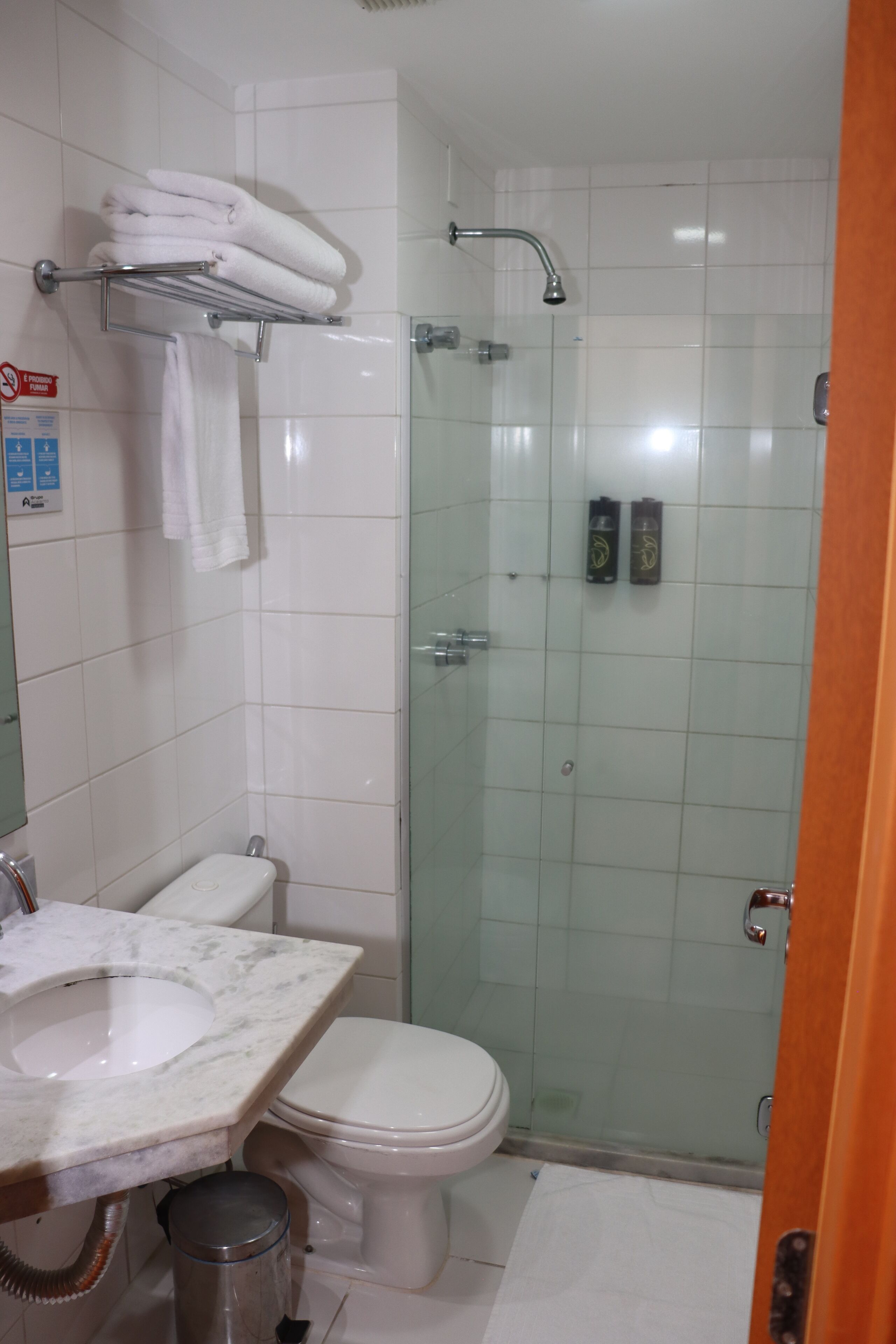 A bathroom with a sink, toilet, and glass shower enclosure.